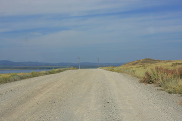 Empty dusty road in the steppe
