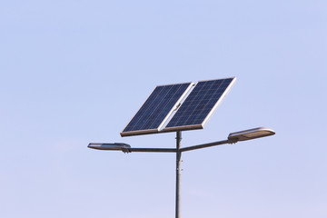street lamp post with solar panel energy (against blue sky background)