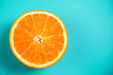 Fresh orange on the light turquoise background. View from above. Place for text.