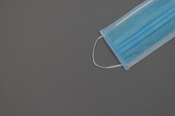 Blue medical mask on grey background. Face mask protection against pollution, virus, flu and coronavirus covid-19. 