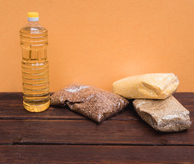 Raw porridge in a package and a bottle of sunflower oil. Stocks of cereals in the package.