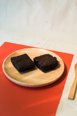 Chocolate brownie on wood plate