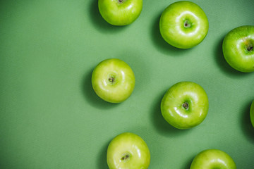 A green apple pattern on the green background. View from above. Place for text.