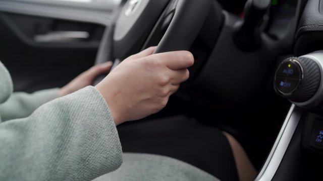 Woman driver driving her crossover suv car, female hands on the steering wheel close-up.