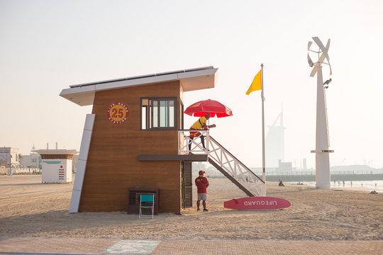 Wooden lifeguard house with faceless lifeguards on the sunset  beach in Dubai