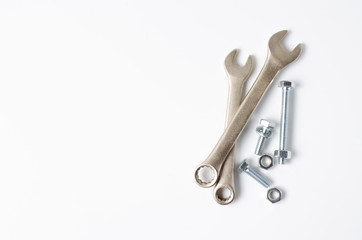 Wrench and bolts with nuts. White background. Copy space