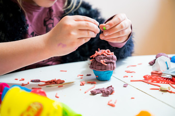 Detail of child's hand working with play dough.