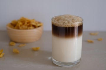 glass of hot macchiato coffee with cereals for breakfast
