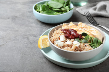 Tasty rice with beans and meat served on grey table