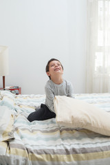 boy having fun in bedroom on the bed