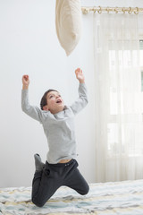 boy having fun in bedroom on the bed