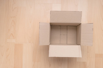 Empty open rectangular cardboard box on wood background. Shopping online object background.