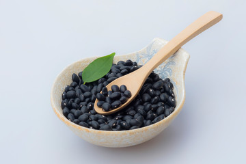 Black Beans seed in wooden spoon with japan ceramic bowl on white background
