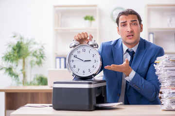 Young male employee making copies at copying machine