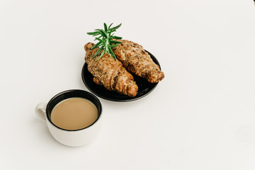 Breakfast with a coffee and organic seed croissants isolated on white.