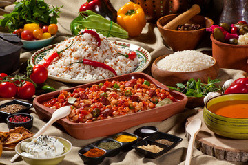 cooked and uncooked haricot beans, served with traditional cooked rice and Traditional red lentil soup. Table garnished with legumes, vegetables and seasonings. Rich cuisine, delicious food.