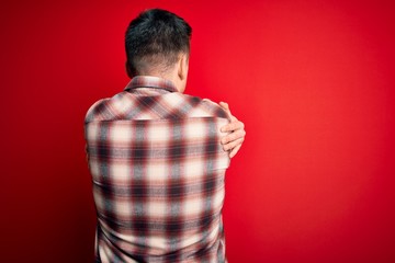 Young handsome caucasian man wearing casual modern shirt over red isolated background Hugging...