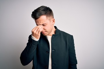 Young handsome business mas wearing elegant winter coat standing over isolated background tired rubbing nose and eyes feeling fatigue and headache. Stress and frustration concept.