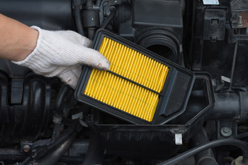 Technician is changing new air filter for car