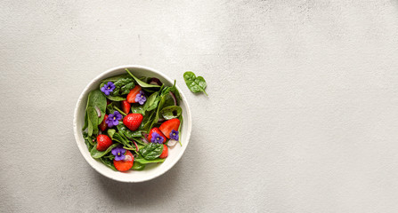 fresh summer salad of spinach, strawberries, onions and balsamic vinegar and edible flowers; 