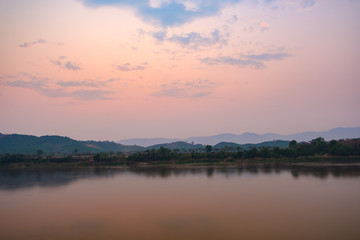 Evening sky behind the mountains.Clouds in the sky .In front of the river