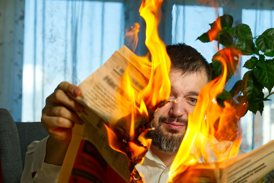 businessman reading hot news or reading stock market news share prices. Burning magazine in man's hands - hot and breaking news concept