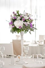 Wedding table decorated on mauve color. Centerpiece full of violet flowers in the middle