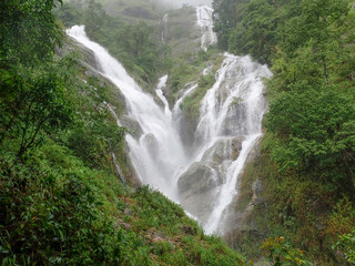 Heart shaped waterfall in the morning covered by morning mist after the rain stopped. Thailand