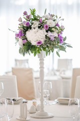 Wedding table decorated on mauve color. Centerpiece full of violet flowers in the middle