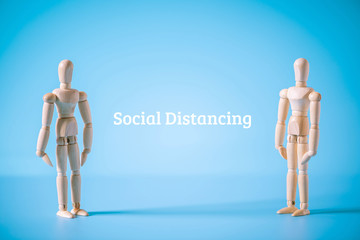 wood models standing between word social distancing. prevent infect from Coronavirus ( COVID-19 ) concept