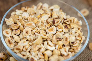 Portion of freshly chopped Hazelnuts (close up; selective focus)