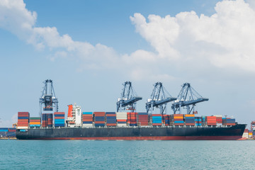 Container ship in asia port while load the job with blue sky