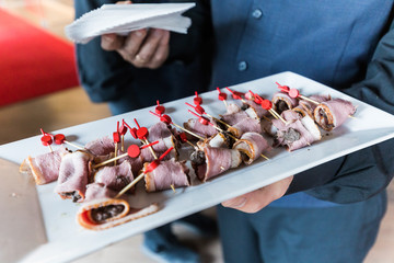 waiter serving ham apetizers