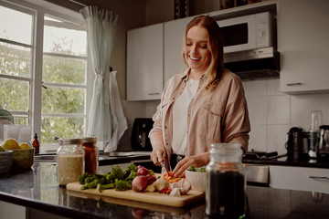 Woman cooking vegetable summer salad in the home kitchen - cooking a healthy vegan meal at home 