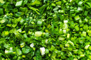 finely chopped green onions dill parsley as background. country style
