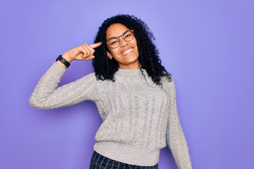 Young african american woman wearing casual sweater and glasses over purple background Smiling pointing to head with one finger, great idea or thought, good memory