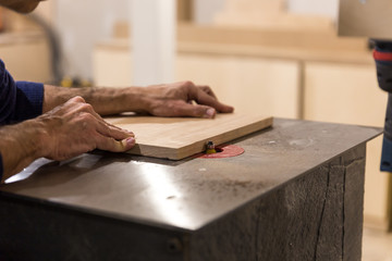 Fototapeta na wymiar hands of a person cutting a wood