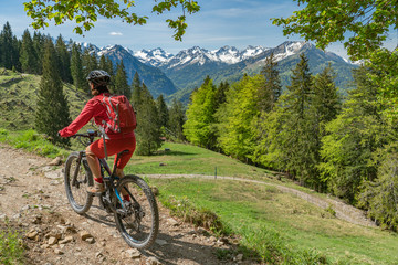 Naklejka premium pretty senior woman riding her electric mountain bike on the Wallraff Trail in the Nebelhorn area above Oberstdorf, Allgau Alps, Bavaria, 