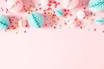 Festive pink background with confetti, paper decoration. Holiday concept on pastel pink background. Birthday, wedding, party. Flat lay, top view, copy space