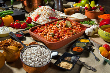 cooked and uncooked haricot beans, served with traditional cooked rice and Traditional red lentil soup. Table garnished with legumes, vegetables and seasonings. Rich cuisine, delicious food.