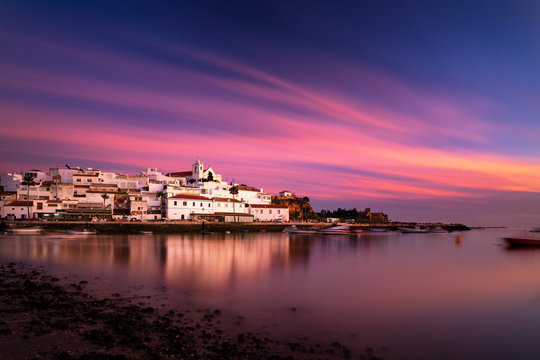 Beautiful view of the traditional village of Ferragudo in Lagoa, Algarve, at sunset, with the traditional houses and boats at the fishing port.