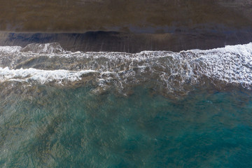Obraz na płótnie Canvas Top view aerial photo from drone of amazing view of volcanic black sand beach