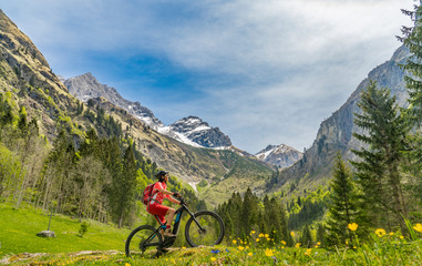 pretty senior woman riding her electric mountain bike the Oy Tal Valley near Oberstdorf, Allgau Alps, Bavaria, Germany
