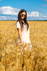 Portrait of a young woman in sunglasses with specular glasses in which white clouds are reflected