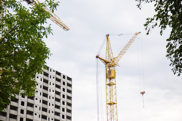 Fototapeta premium construction of iron-concrete high-rise building. Construction workplace in the summer. Details of unfinished building on the construction site. The erection of a new residential multi-storey house