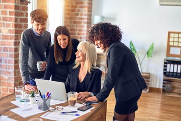 Group of business workers smiling happy and confident. Working together with smile on face  using laptop at the office