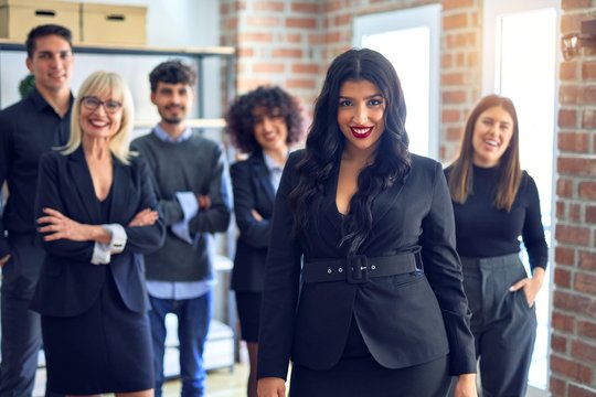 Group of business workers smiling happy and confident. Posing together looking at the camera, young beautiful woman with smile on face at the office