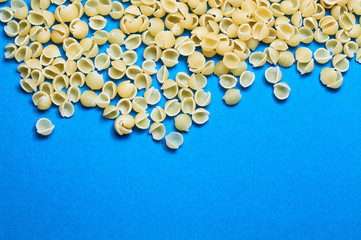 Blue background and Italian noodles, spaghetti, pasta of different forms of wheat in raw.