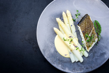 Gebratenes Gourmet Skrei Kabeljau Fisch Filet mit weißen Spargel und Sauce Hollandaise angeboten...