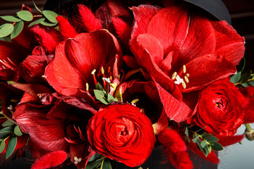 macro view of exquisite bouquet made from red lilies, roses, and fresh greenery
